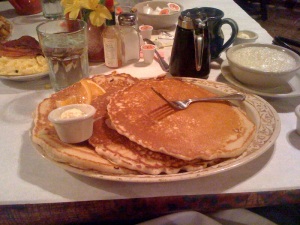 A stack of three plate-sized pancakes.